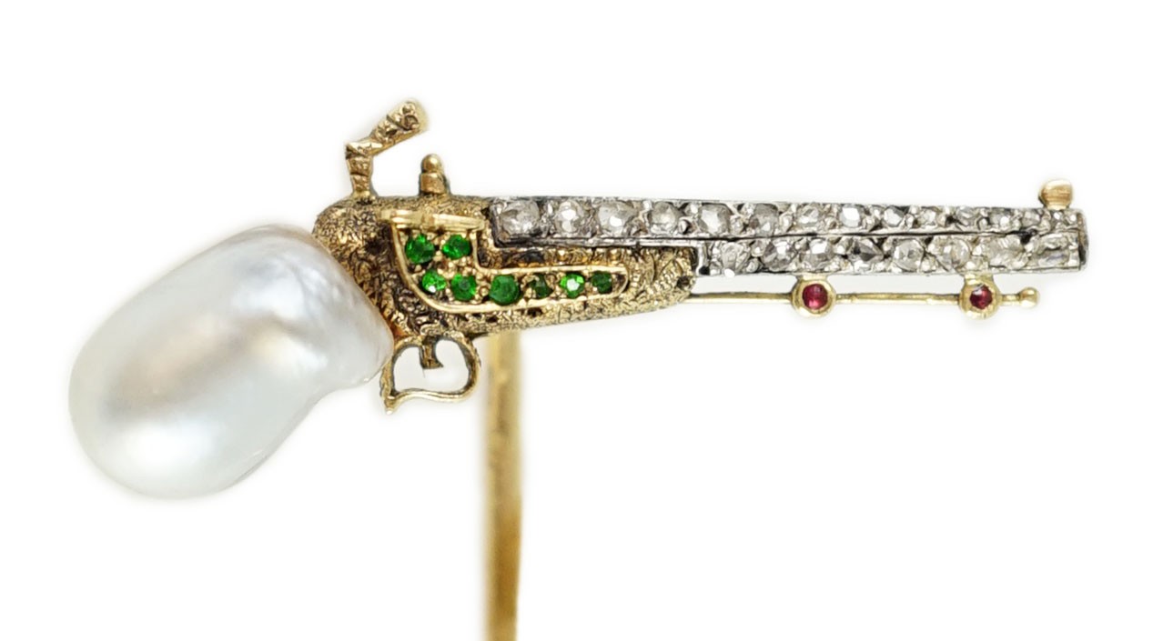 An early 20th century French Chaumet & Co 18ct gold, natural saltwater baroque pearl, demantoid garnet, ruby and rose cut diamond set novelty stick pin, modelled as a pistol